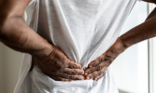 A man holding his lower back in pain