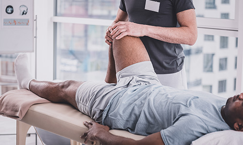 Man getting massaged around his leg and knee