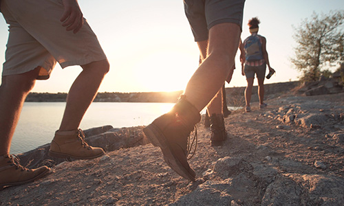 View of hiker's legs as they walk around a lake