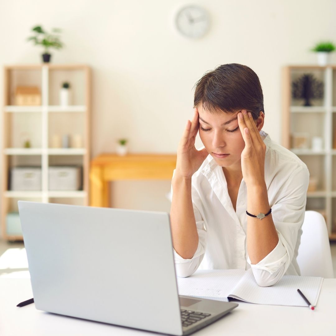 Woman with a headache holding her temples