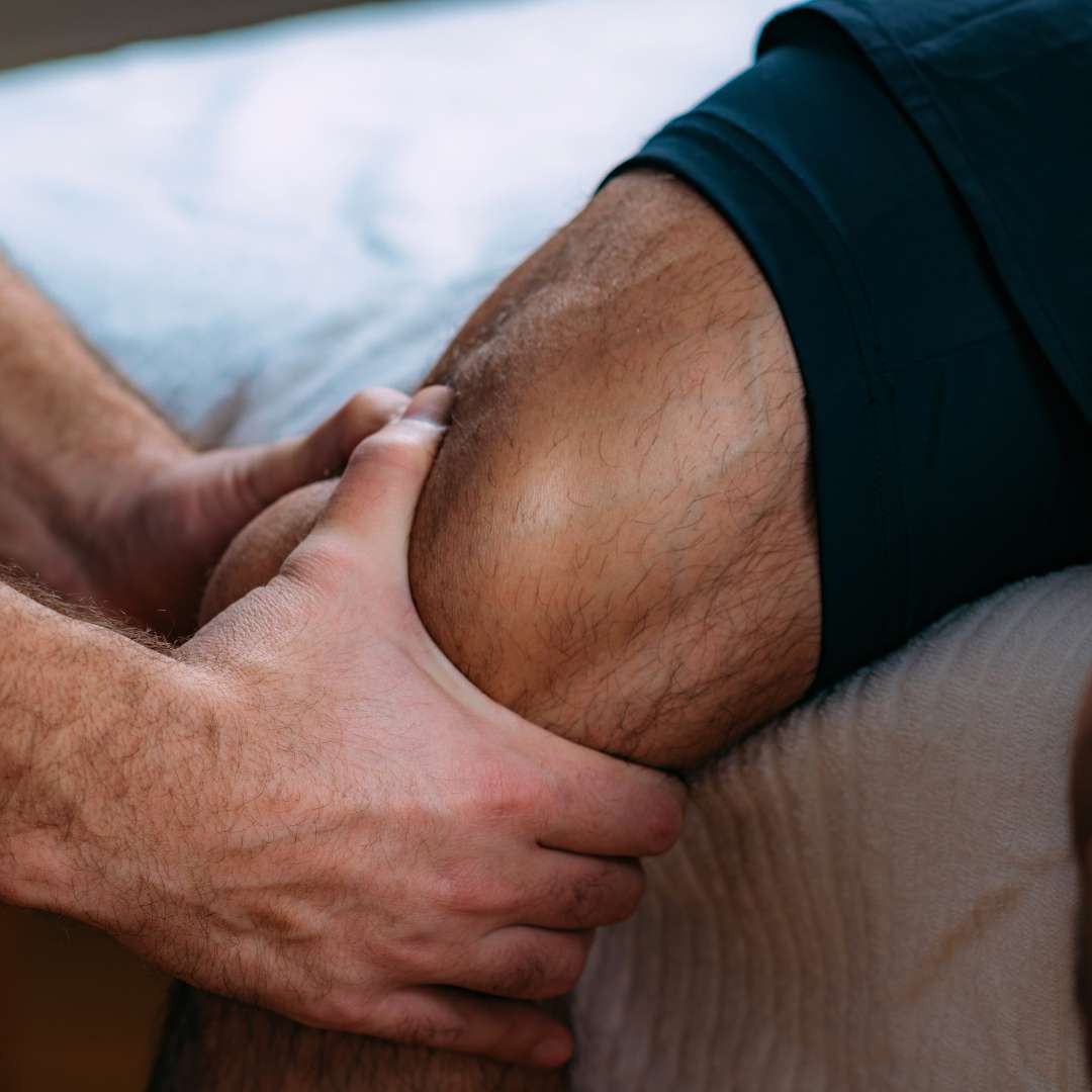 physical therapist massaging patient's quad