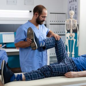 Therapist raising patient's leg during rehabilitation session