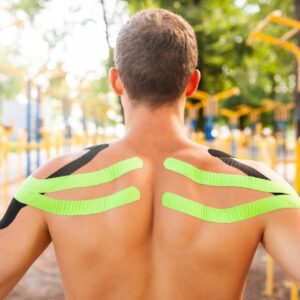 Athlete with green kinesiology tape on shoulders outdoors