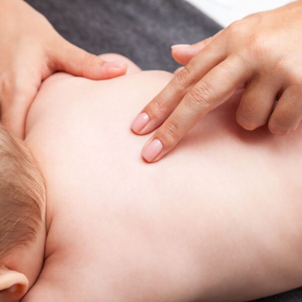 two fingers feeling a baby's spine
