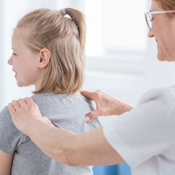 chiropractor feeling a girl's shoulders