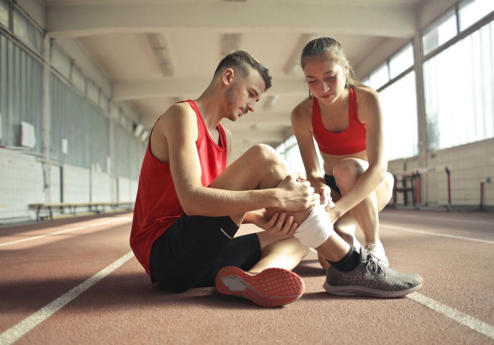 A women helping wrap the shin of a man